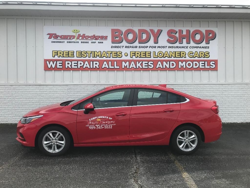 Red loaner car parked outside Team Hodges Body Shop