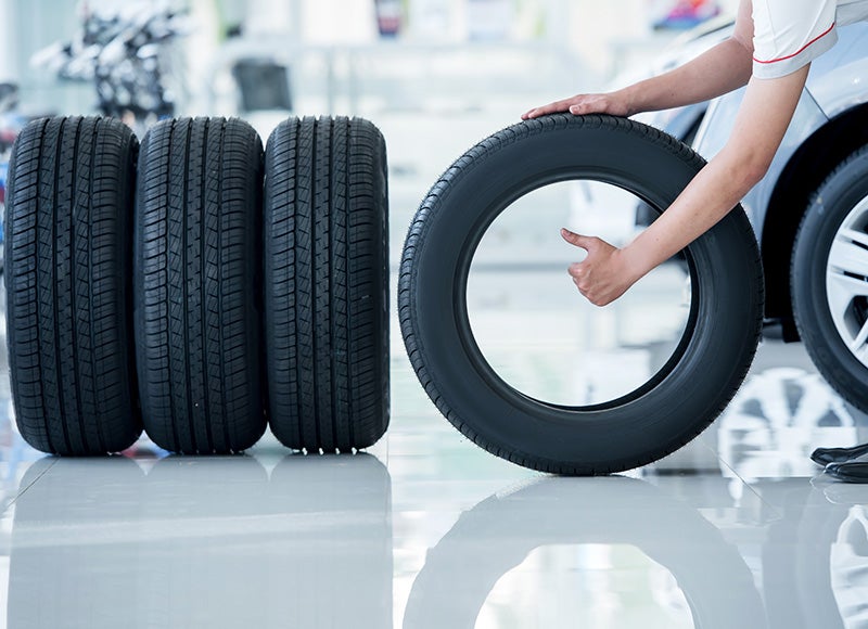 Technician lining up tires at auto service center